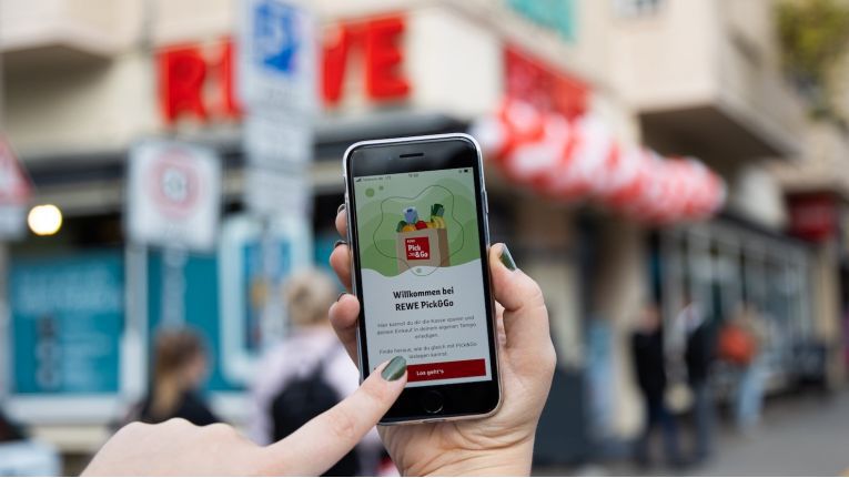 Rewe bietet mit "Pick & Go" ein Konzept an, bei dem Kunden in Märkten einkaufen können, ohne die Waren an einer Kasse zu bezahlen. Die Rechnung erhalten sie via App.